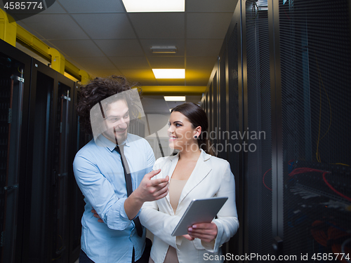 Image of engineer showing working data center server room to female chief