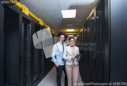 Image of engineer showing working data center server room to female chief