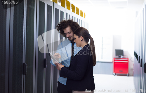 Image of engineer showing working data center server room to female chief