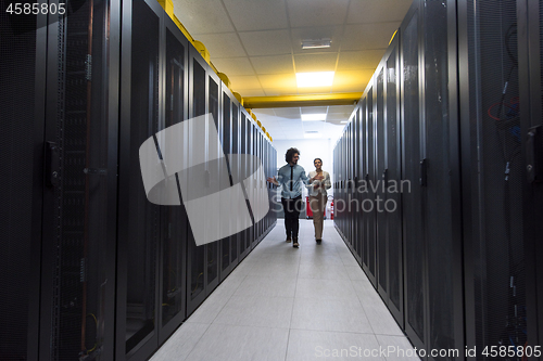 Image of engineer showing working data center server room to female chief