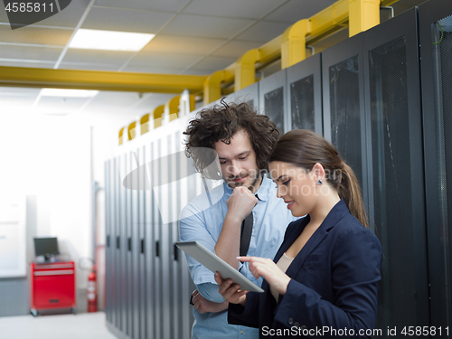 Image of engineer showing working data center server room to female chief