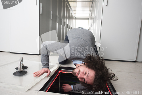 Image of engineer connecting cables in server room