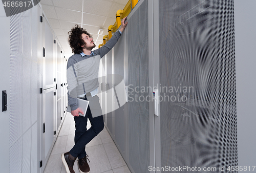 Image of IT engineer working on a tablet computer in server room