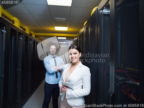 Image of engineer showing working data center server room to female chief