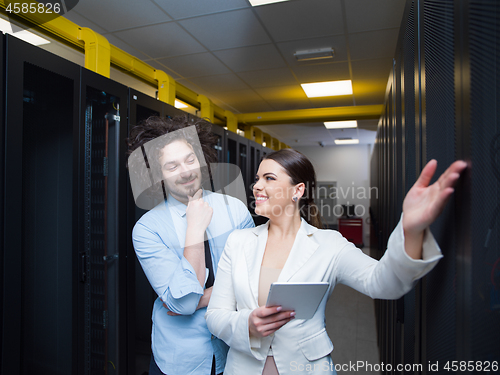 Image of engineer showing working data center server room to female chief