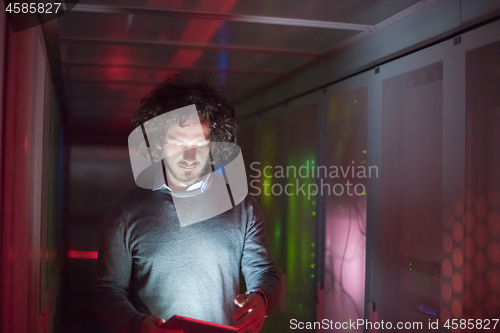 Image of IT engineer working on a tablet computer in server room