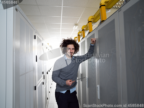 Image of IT engineer working on a tablet computer in server room