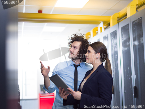 Image of engineer showing working data center server room to female chief