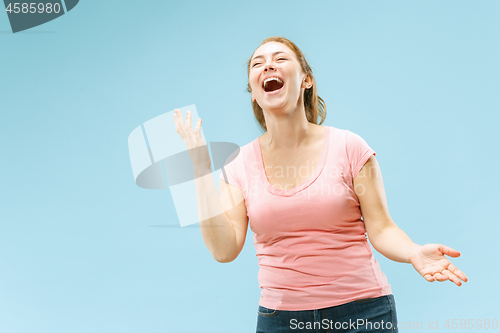 Image of The happy business woman standing and smiling against pastel background.