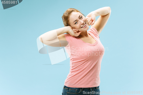 Image of The happy business woman standing and smiling against pastel background.