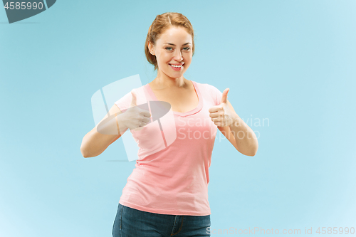 Image of The happy business woman standing and smiling against blue background.