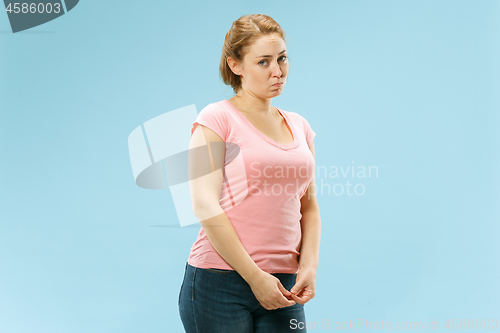 Image of Beautiful woman looking suprised and bewildered isolated on blue