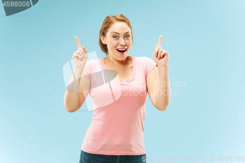 Image of The happy business woman standing and smiling against pastel background.
