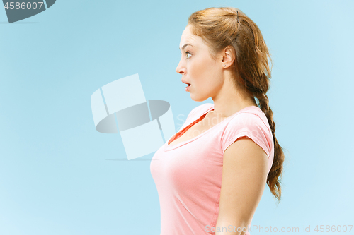 Image of Beautiful woman looking suprised isolated on blue