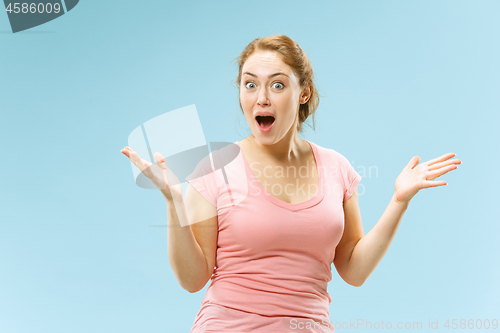 Image of Beautiful woman looking suprised isolated on blue