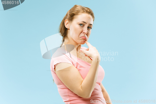 Image of Beautiful woman looking suprised and bewildered isolated on blue