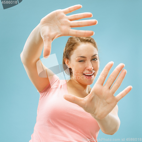 Image of The happy business woman standing and smiling against pastel background.