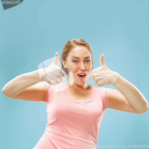 Image of The happy business woman standing and smiling against blue background.