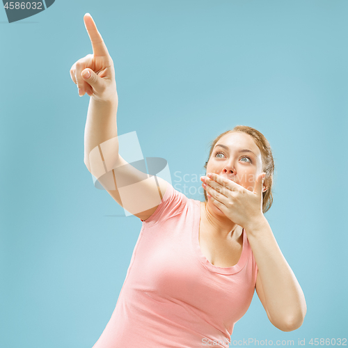 Image of Beautiful woman looking suprised isolated on blue