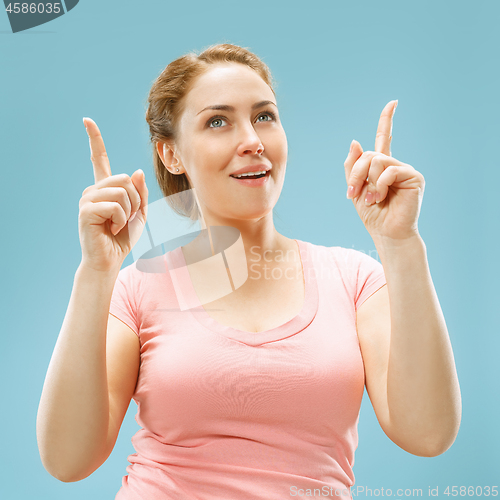 Image of Beautiful woman looking suprised isolated on blue