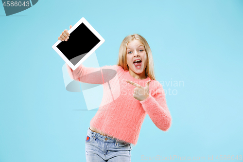 Image of Little funny girl with tablet on blue background