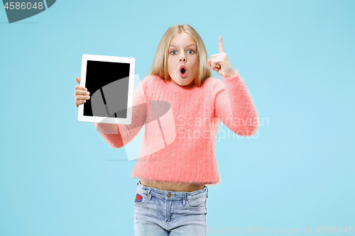 Image of Little funny girl with tablet on blue background