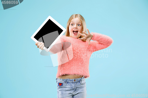 Image of Little funny girl with tablet on blue background