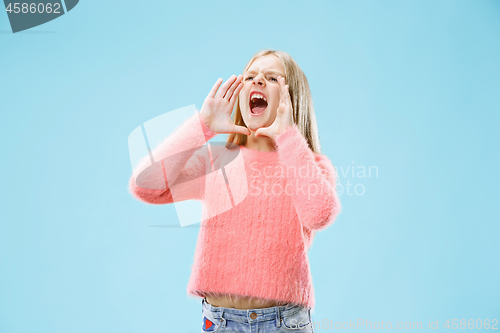 Image of Isolated on blue young casual teen girl shouting at studio