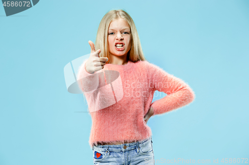 Image of The happy teen girl pointing to you, half length closeup portrait on blue background.