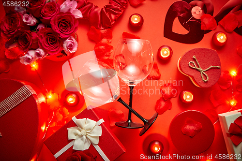 Image of Valentines day romantic decoration with roses, wine glasses, boxed gifts, candles