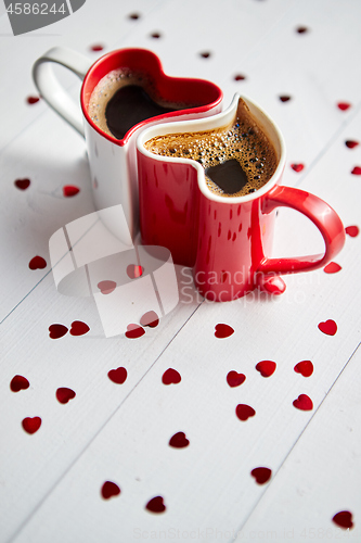 Image of Two heart shaped coffee cups conected with each other.