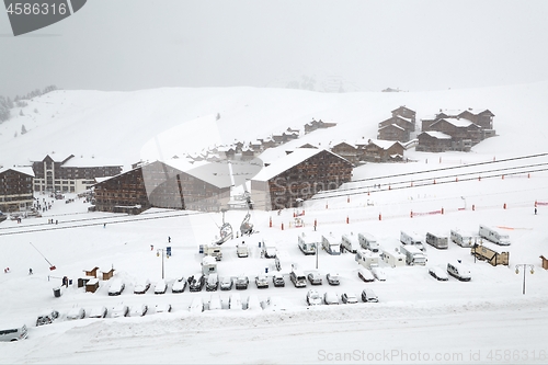 Image of Snowy mountain skiing village, falling snow