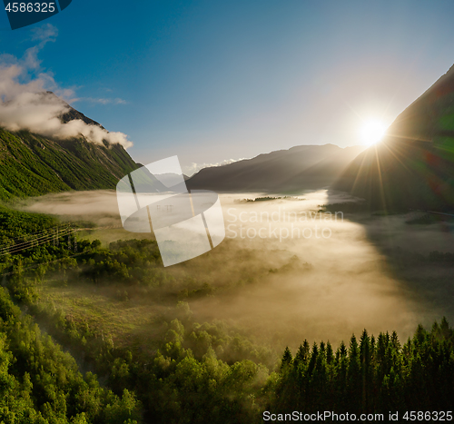 Image of Morning mist over the valley among the mountains in the sunlight