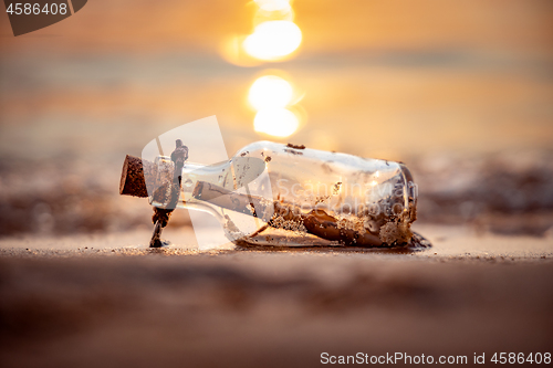 Image of Message in the bottle against the Sun setting down