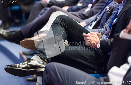 Image of Row of business people sitting at seminar.