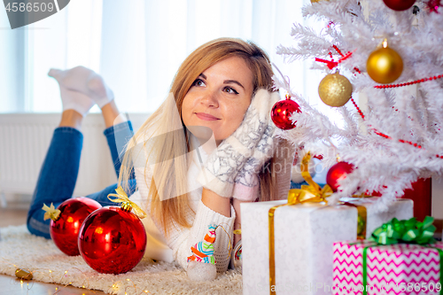 Image of Girl dreams of a gift lying at the Christmas tree