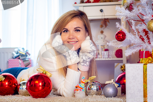 Image of Portrait of a young girl lying at a Christmas tree