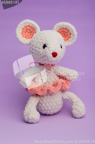 Image of Knitted with his hands toy mouse on a lilac background