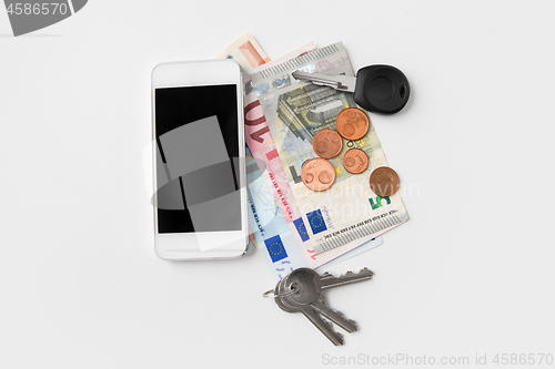 Image of close up of smartphone, euro money and keys