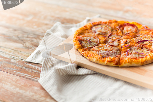 Image of close up of homemade pizza on wooden table