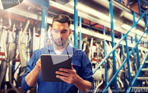 Image of auto mechanic or smith with tablet pc at workshop