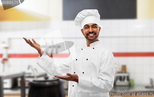 Image of happy male indian chef at restaurant kitchen