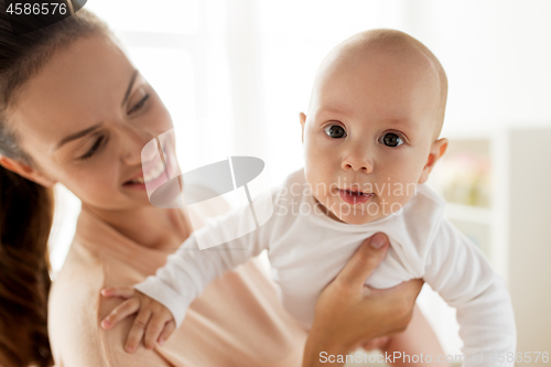 Image of happy mother playing with little baby boy at home