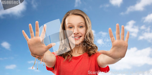 Image of happy teenage girl giving high five over sky