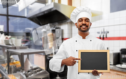 Image of happy indian chef with chalkboard at kebab shop