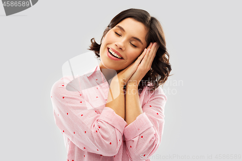 Image of happy woman in pajama making sleeping gesture