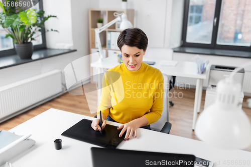 Image of designer with computer and pen tablet at office