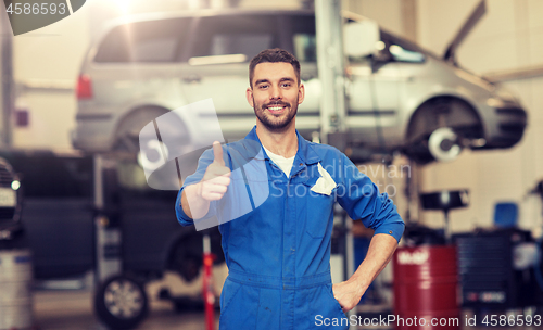 Image of happy auto mechanic man or smith at car workshop