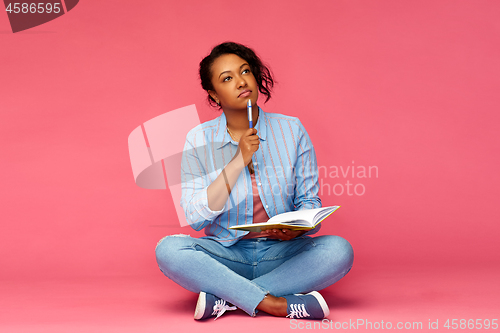 Image of student woman with diary or notebook thinking