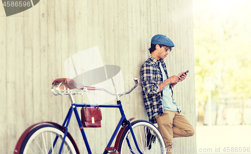 Image of man with smartphone, earphones and bicycle